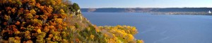 Scenic view of a lake surrounded by autumn trees and hills.
