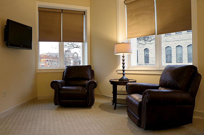 Cozy living room with leather armchairs and warm lighting.